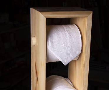 A toilet paper tower made out of scrap pine wood.